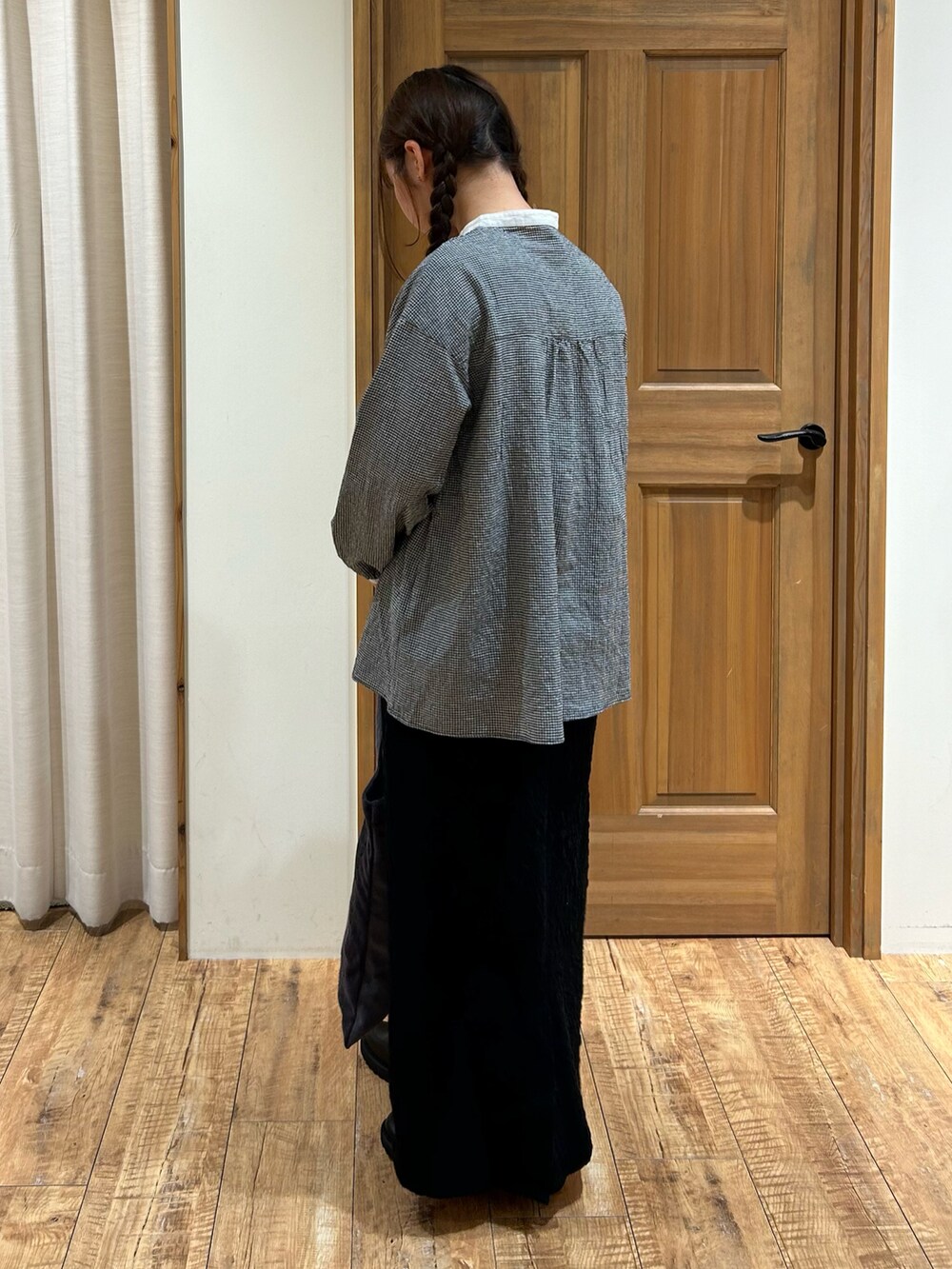 ブラック系のシャツ/ブラウス、ブラック系のスカート、グレー系のハンドバッグを着用したレディースの秋コーディネートの4枚目の写真