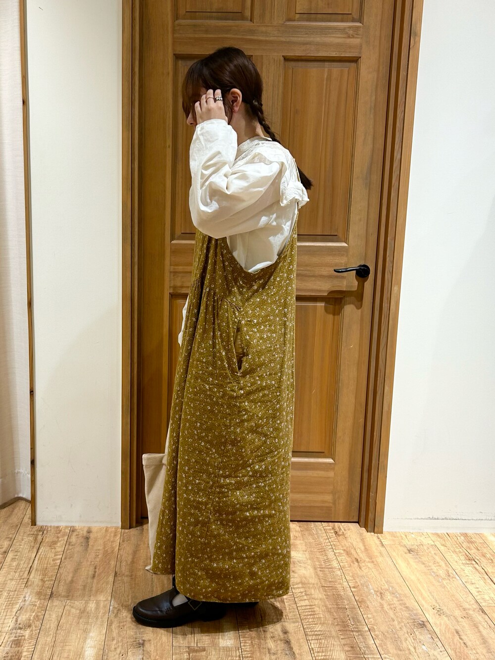 ホワイト系のシャツ/ブラウス、イエロー系のワンピース、ベージュ系のハンドバッグを着用したレディースの秋コーディネートの4枚目の写真