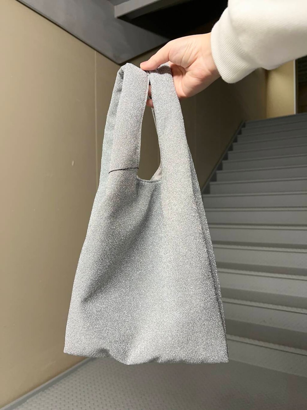 ブルー系のデニムパンツ、シルバー系のトートバッグ、ピンク系のシャツ/ブラウスを着用したレディースの冬コーディネートの4枚目の写真