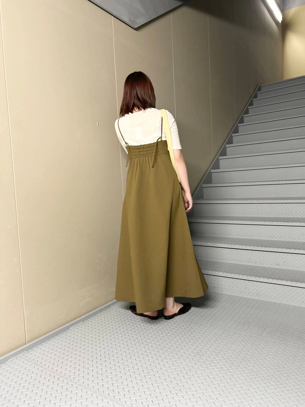 イエロー系のショルダーバッグ、ブラウン系のその他シューズ、ホワイト系のTシャツ/カットソーを着用したレディースの夏コーディネートの3枚目の写真