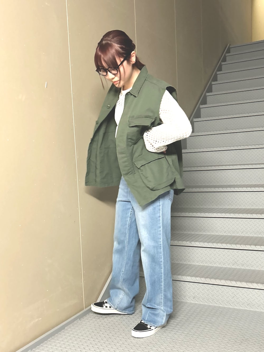 ブルー系のデニムパンツ、ホワイト系のニット/セーター、グリーン系のベストを着用したレディースの冬コーディネートの3枚目の写真