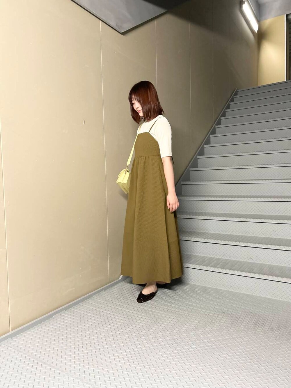 イエロー系のショルダーバッグ、ブラウン系のその他シューズ、ホワイト系のTシャツ/カットソーを着用したレディースの夏コーディネートの2枚目の写真