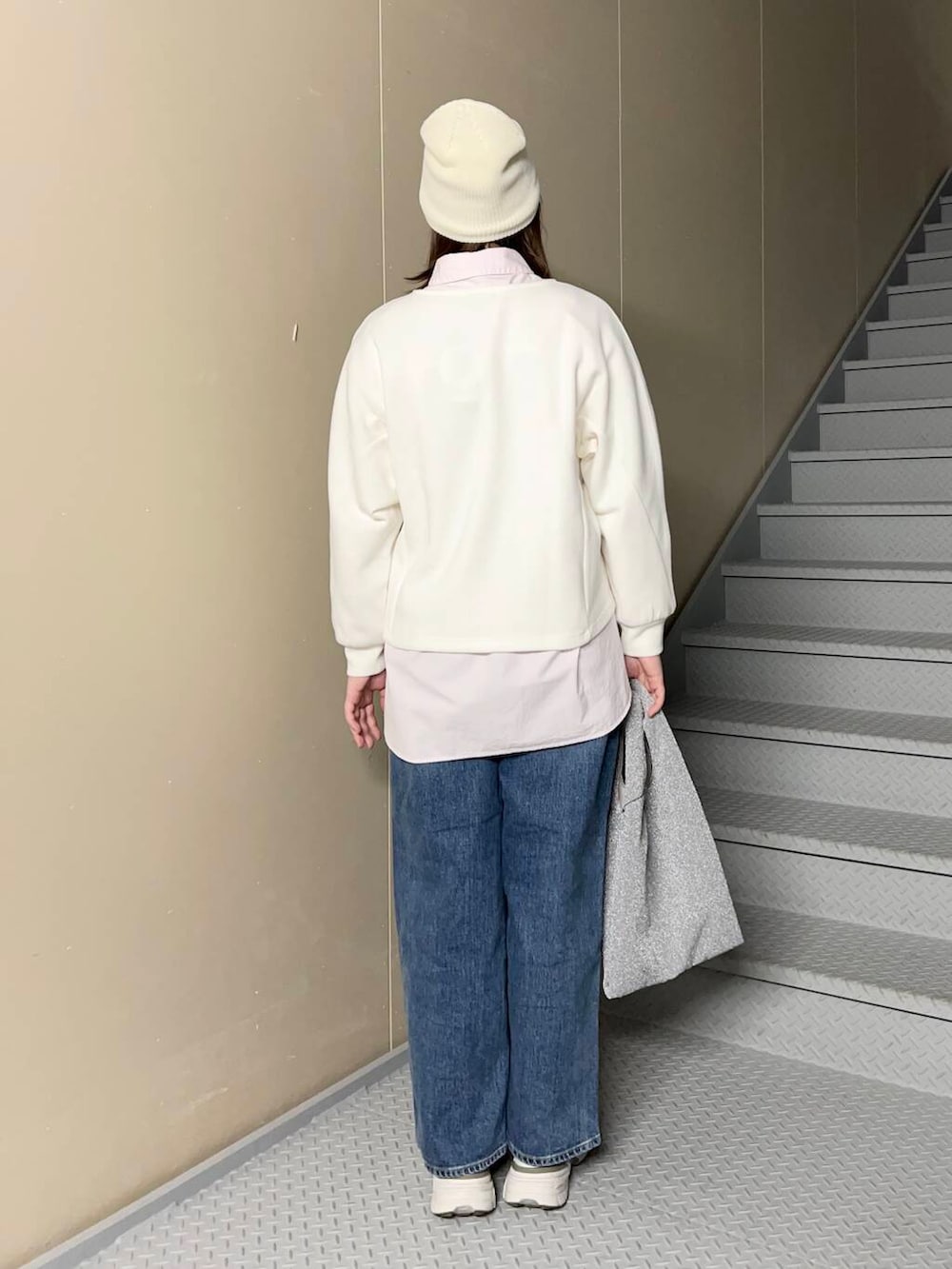 ブルー系のデニムパンツ、シルバー系のトートバッグ、ピンク系のシャツ/ブラウスを着用したレディースの冬コーディネートの3枚目の写真