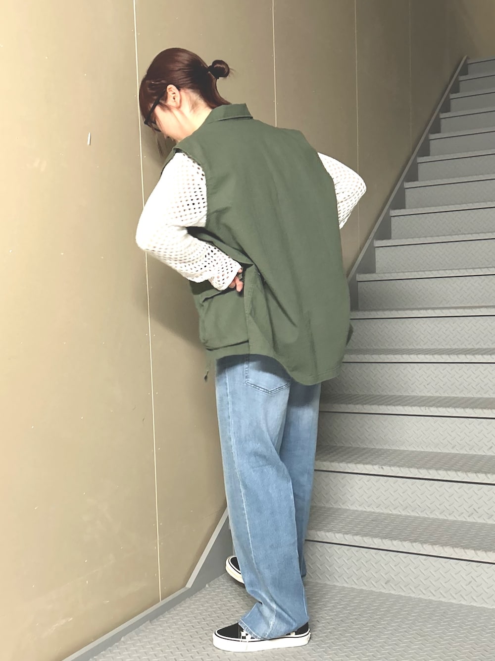 ブルー系のデニムパンツ、ホワイト系のニット/セーター、グリーン系のベストを着用したレディースの冬コーディネートの4枚目の写真