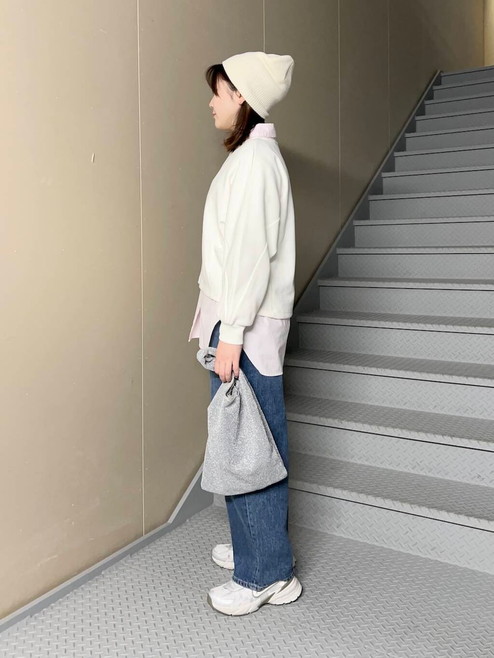 ブルー系のデニムパンツ、シルバー系のトートバッグ、ピンク系のシャツ/ブラウスを着用したレディースの冬コーディネートの2枚目の写真