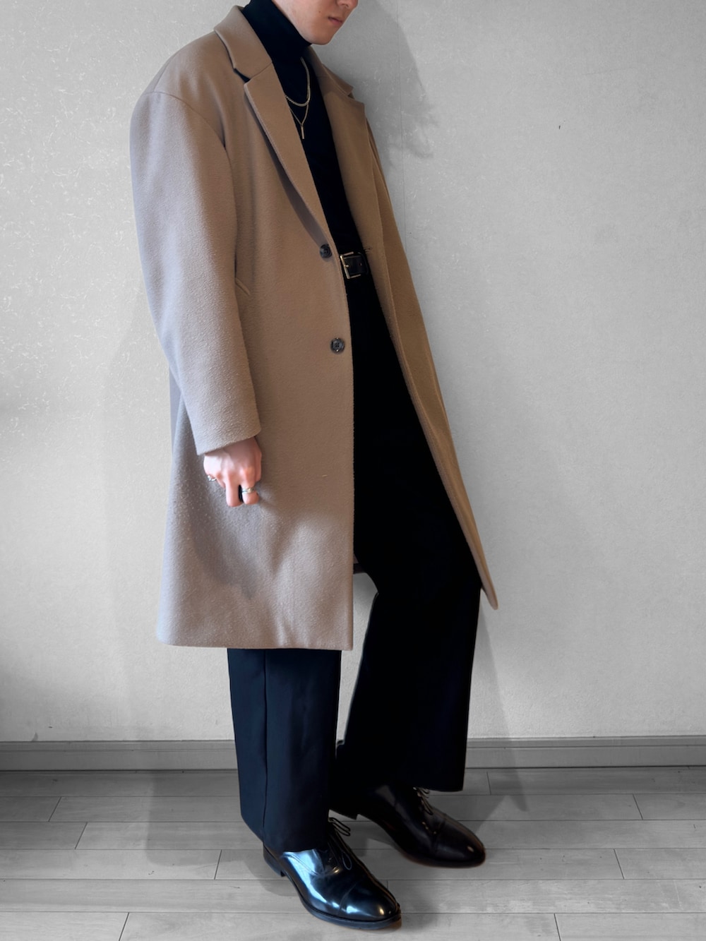 ブラック系のドレスシューズ、ブラック系のパンツ、ブラック系のニット/セーターを着用したメンズの冬コーディネートの2枚目の写真