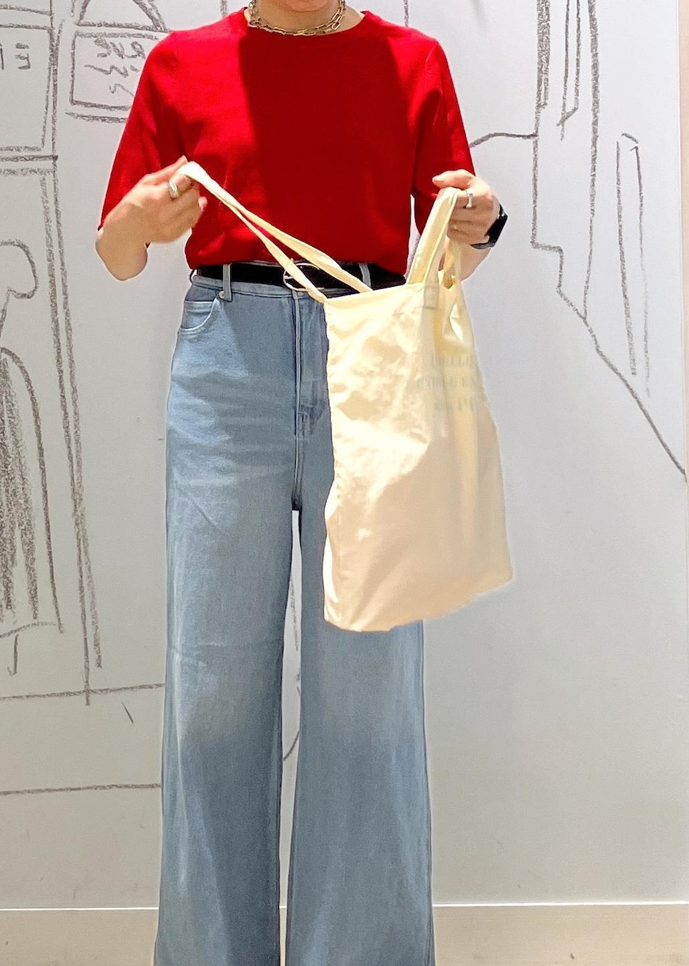 ブルー系のデニムパンツ、ブラック系のスニーカー、ホワイト系のトートバッグを着用したレディースの夏コーディネートの7枚目の写真