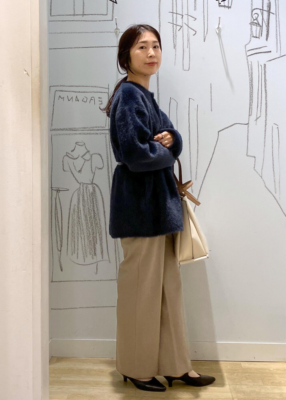 ブラック系のパンプス、ホワイト系のトートバッグ、ベージュ系のその他パンツを着用したレディースの秋コーディネートの2枚目の写真