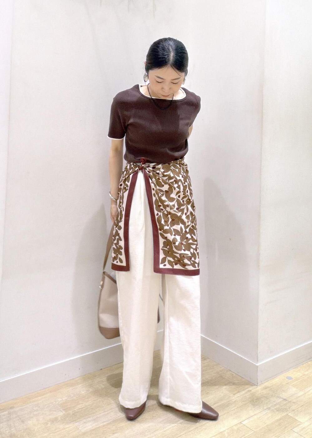 ブラウン系のパンプス、ブラウン系のニット/セーター、ホワイト系のショルダーバッグを着用したレディースの夏コーディネートの5枚目の写真