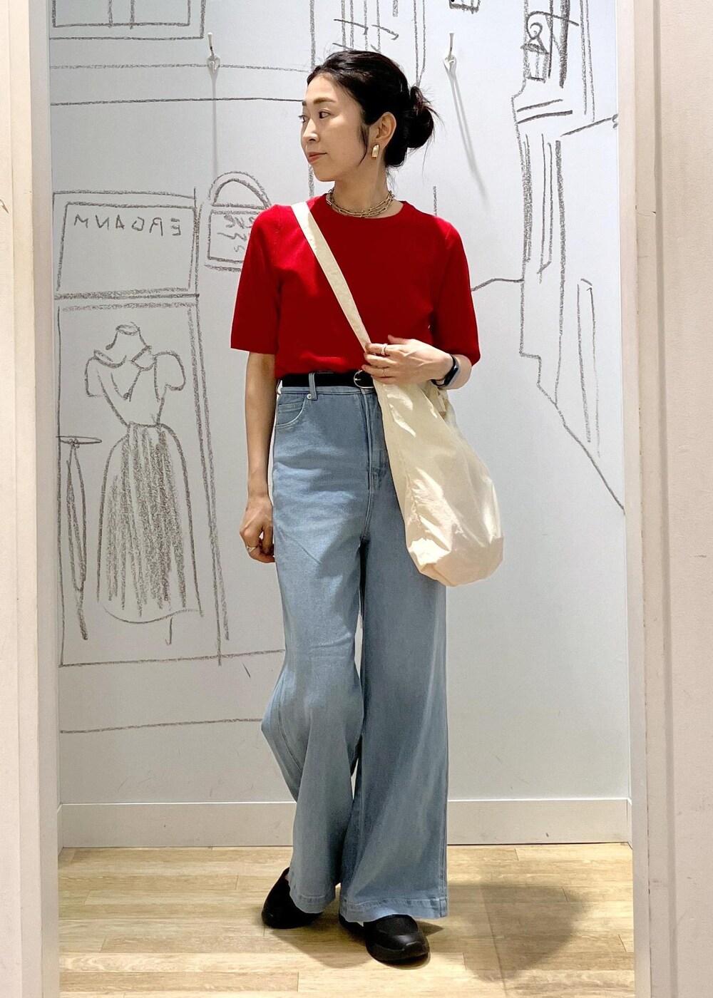 ブルー系のデニムパンツ、ブラック系のスニーカー、ホワイト系のトートバッグを着用したレディースの夏コーディネートの5枚目の写真