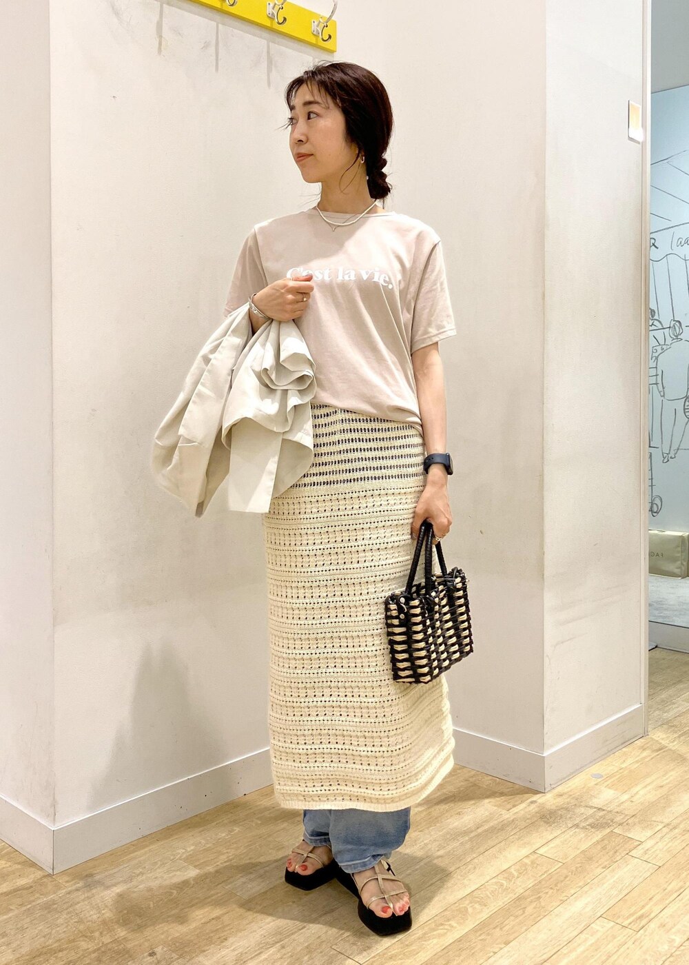 ブルー系のデニムパンツ、ホワイト系のスカート、ベージュ系のTシャツ/カットソーを着用したレディースの夏コーディネートの4枚目の写真