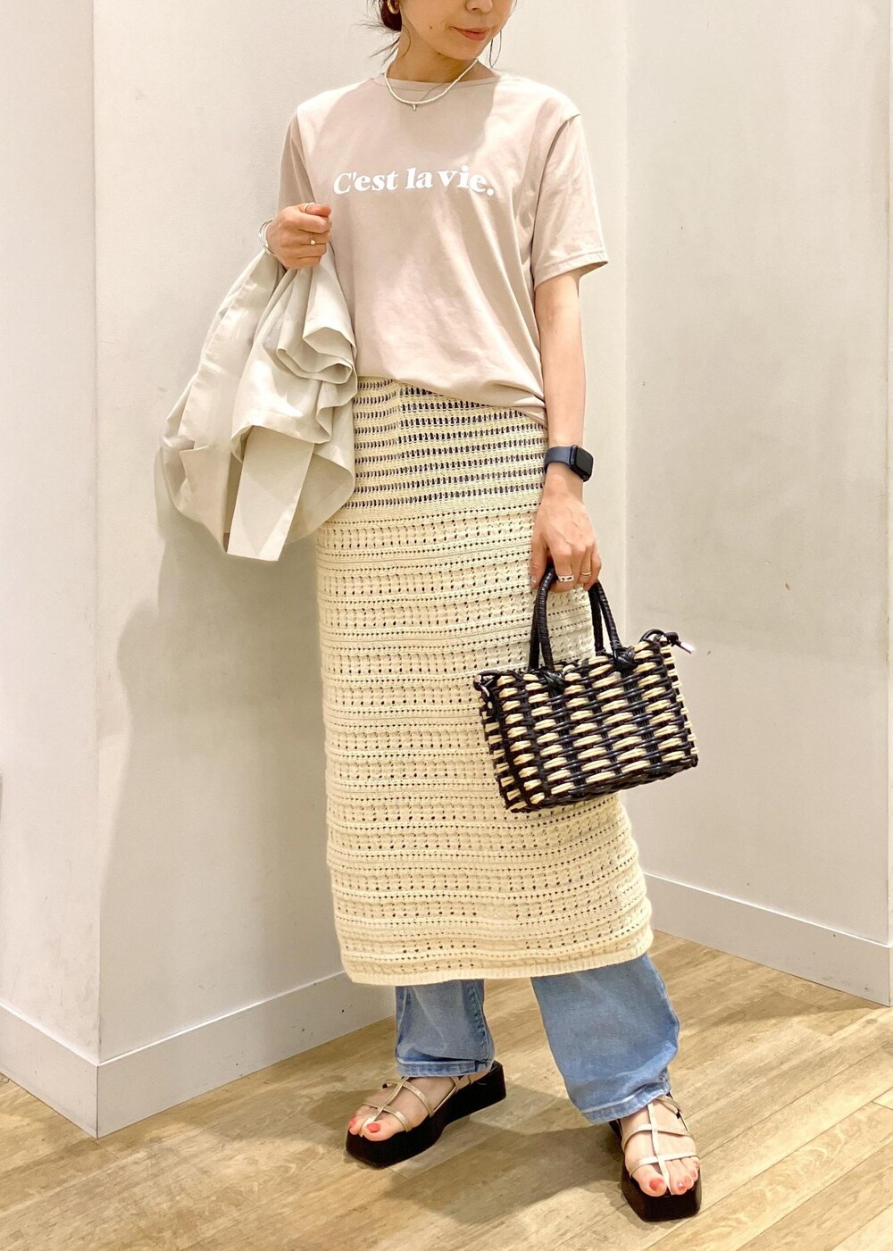 ブルー系のデニムパンツ、ホワイト系のスカート、ベージュ系のTシャツ/カットソーを着用したレディースの夏コーディネートの3枚目の写真