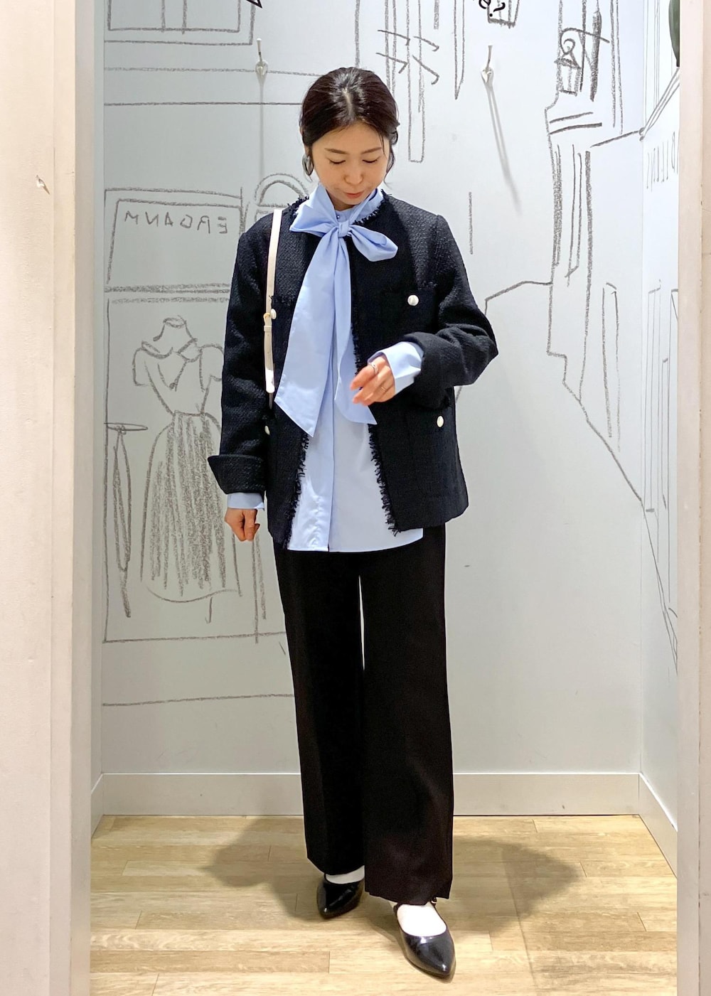 ブラック系のパンプス、ブラック系のその他パンツ、ホワイト系のショルダーバッグを着用したレディースの冬コーディネートの2枚目の写真