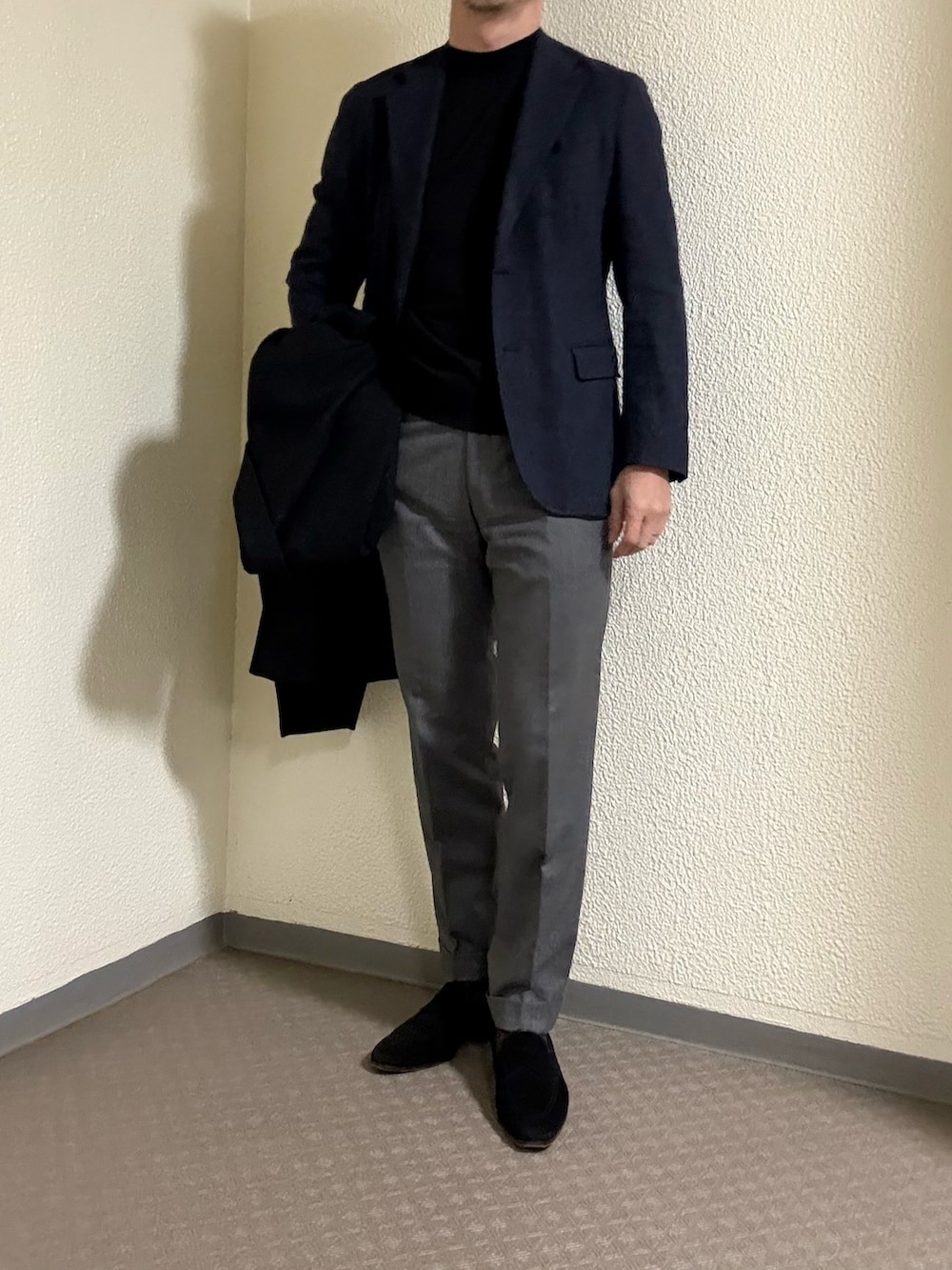 グレー系のチェスターコート、グレー系のスラックス、ブラック系のローファーを着用したメンズの冬コーディネートの2枚目の写真