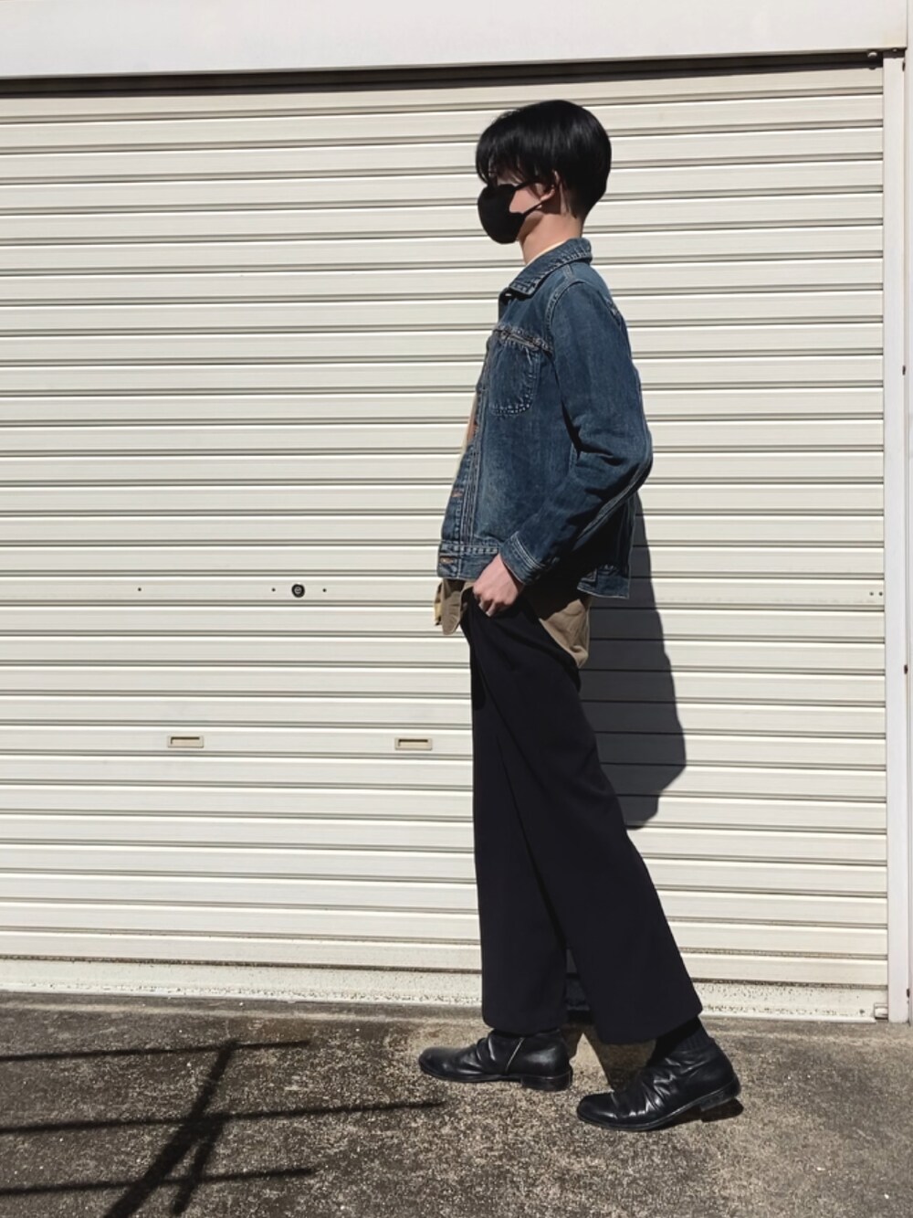 ブラック系のパンツ、ブラック系のブーツ、ブルー系のデニムジャケットを着用したメンズの冬コーディネートの2枚目の写真