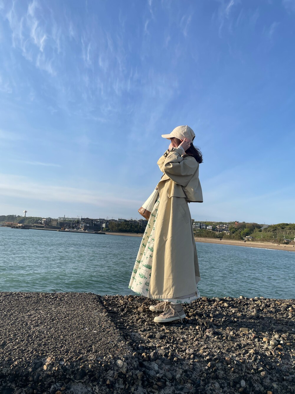 グリーン系のスカート、ベージュ系のスニーカー、ベージュ系のショルダーバッグを着用したレディースの夏コーディネートの2枚目の写真