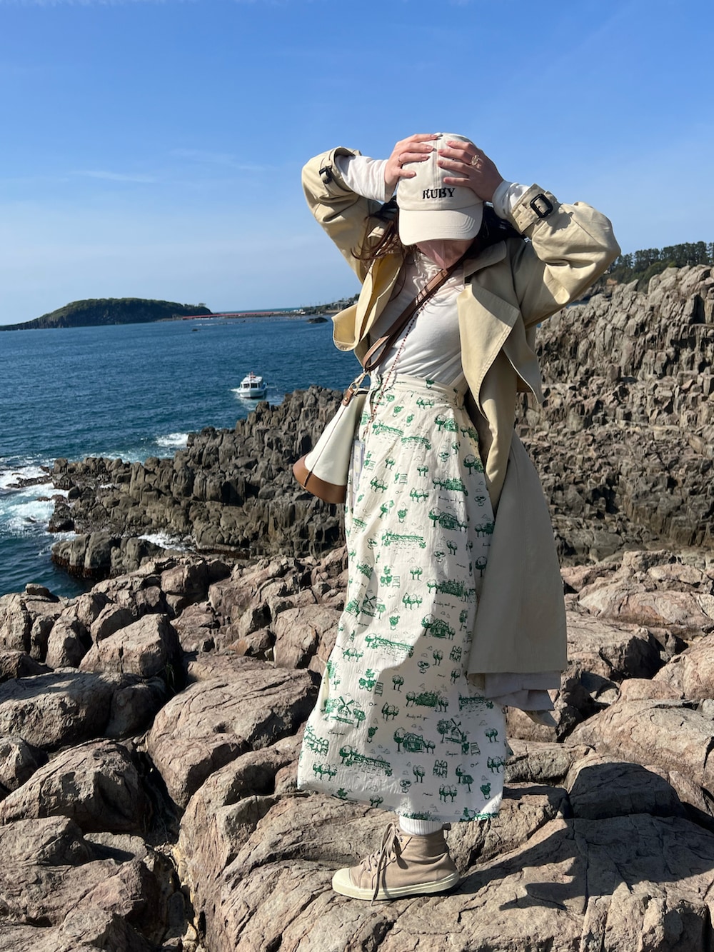 グリーン系のスカート、ベージュ系のスニーカー、ベージュ系のショルダーバッグを着用したレディースの夏コーディネートの3枚目の写真