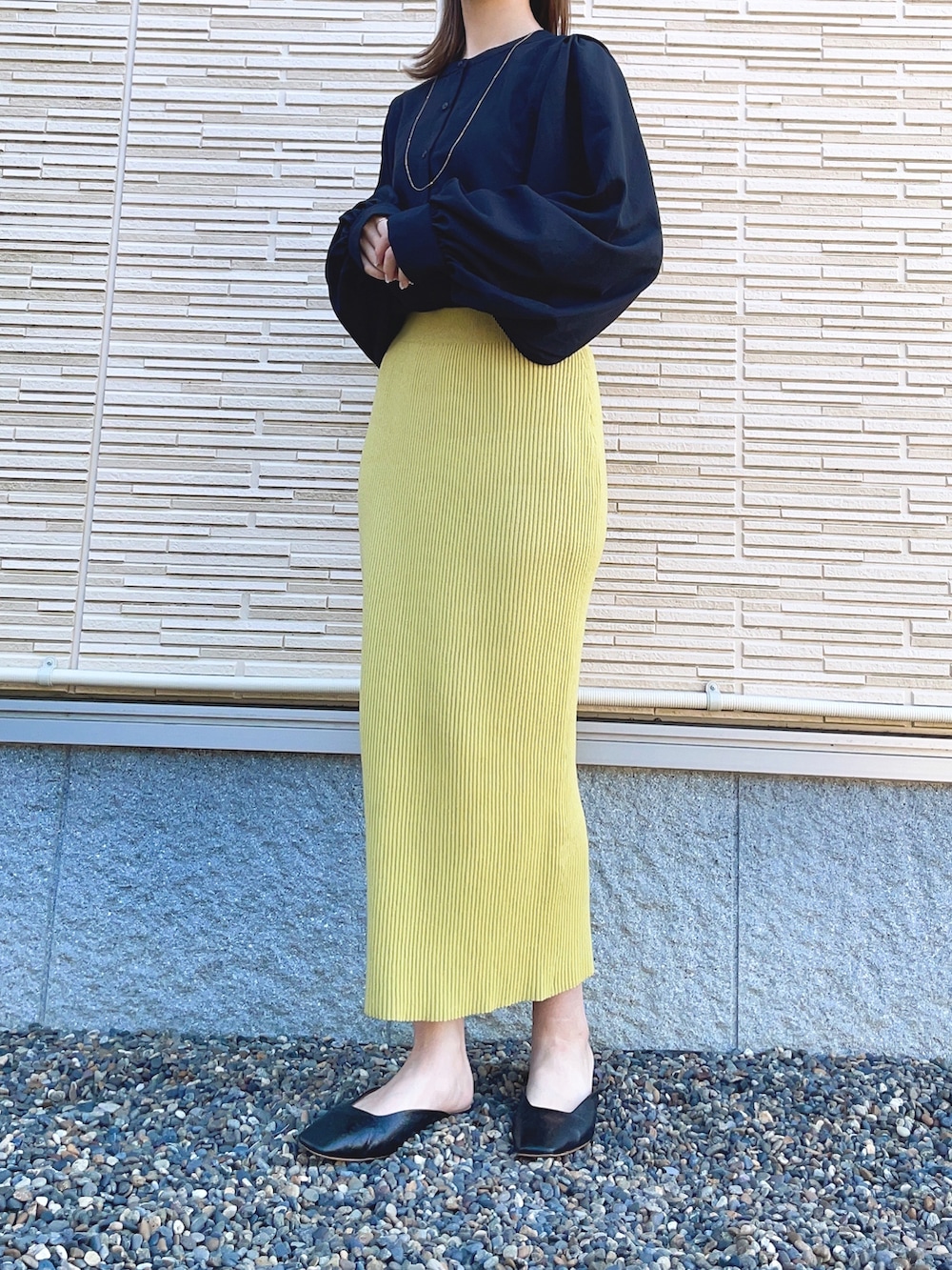 ブラック系のシャツ/ブラウス、ブラック系のテーラードジャケット、イエロー系のスカートを着用したレディースの春コーディネートの2枚目の写真