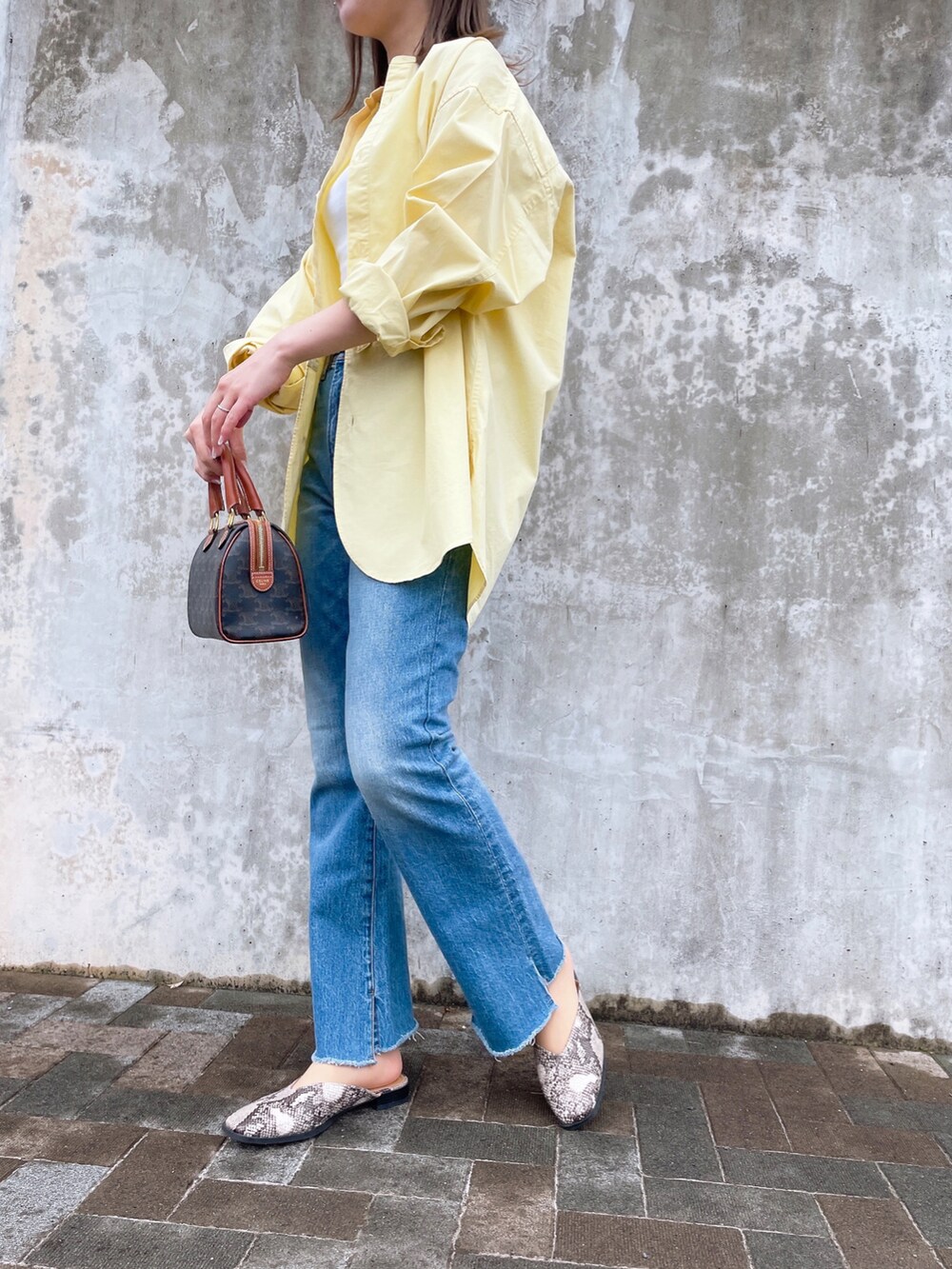 ホワイト系のタンクトップ、イエロー系のシャツ/ブラウス、ブルー系のデニムパンツを着用したレディースの春コーディネートの2枚目の写真