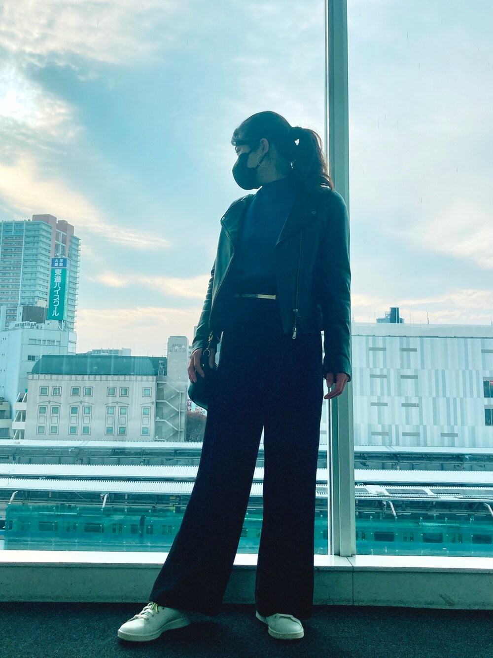 ブラック系のスラックス、ホワイト系のスニーカー、ブラック系のショルダーバッグを着用したレディースの秋コーディネートの2枚目の写真