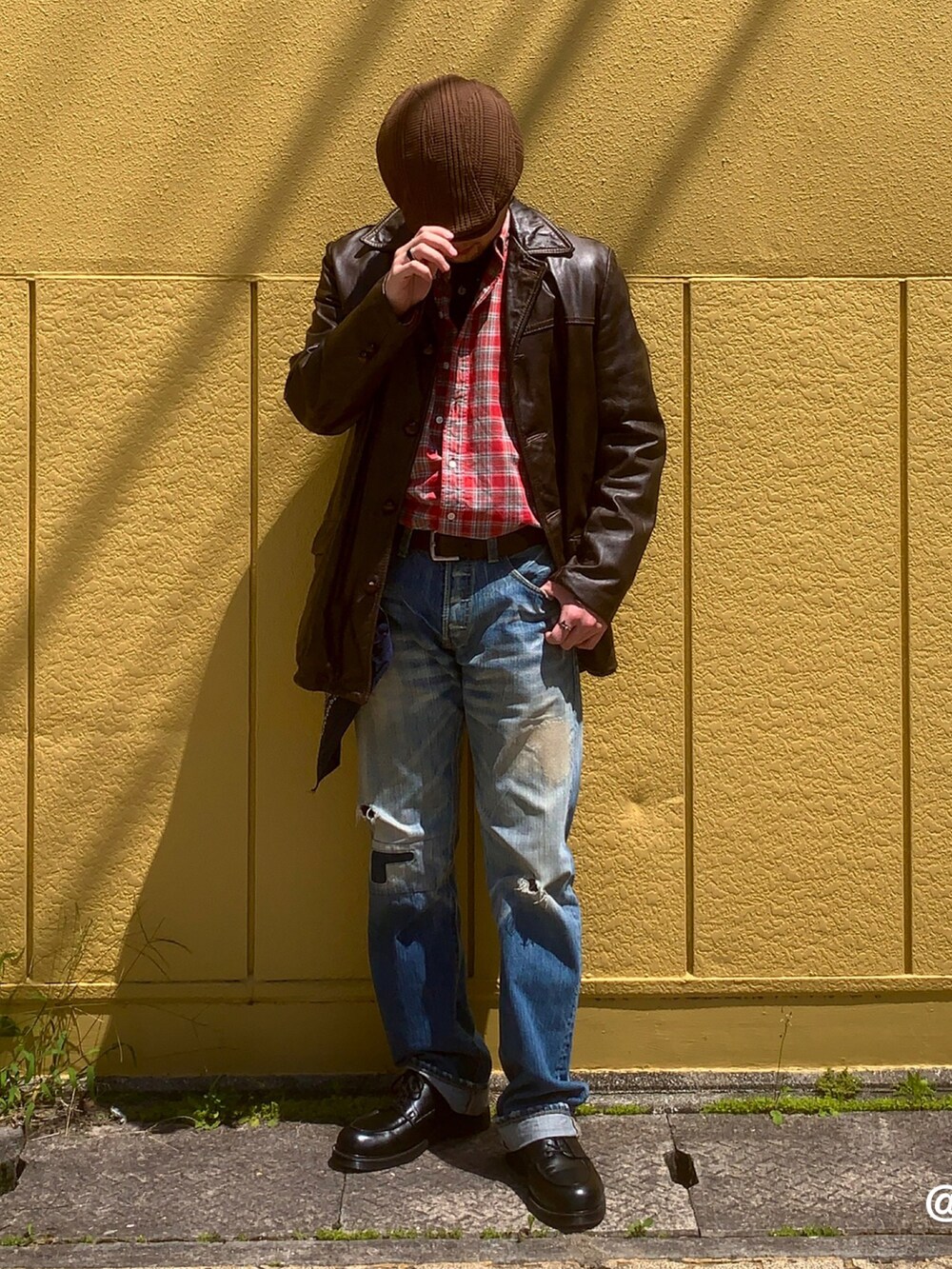 ブラック系のドレスシューズ、レッド系のトップス、ブルー系のデニムパンツを着用したメンズの春コーディネートの5枚目の写真