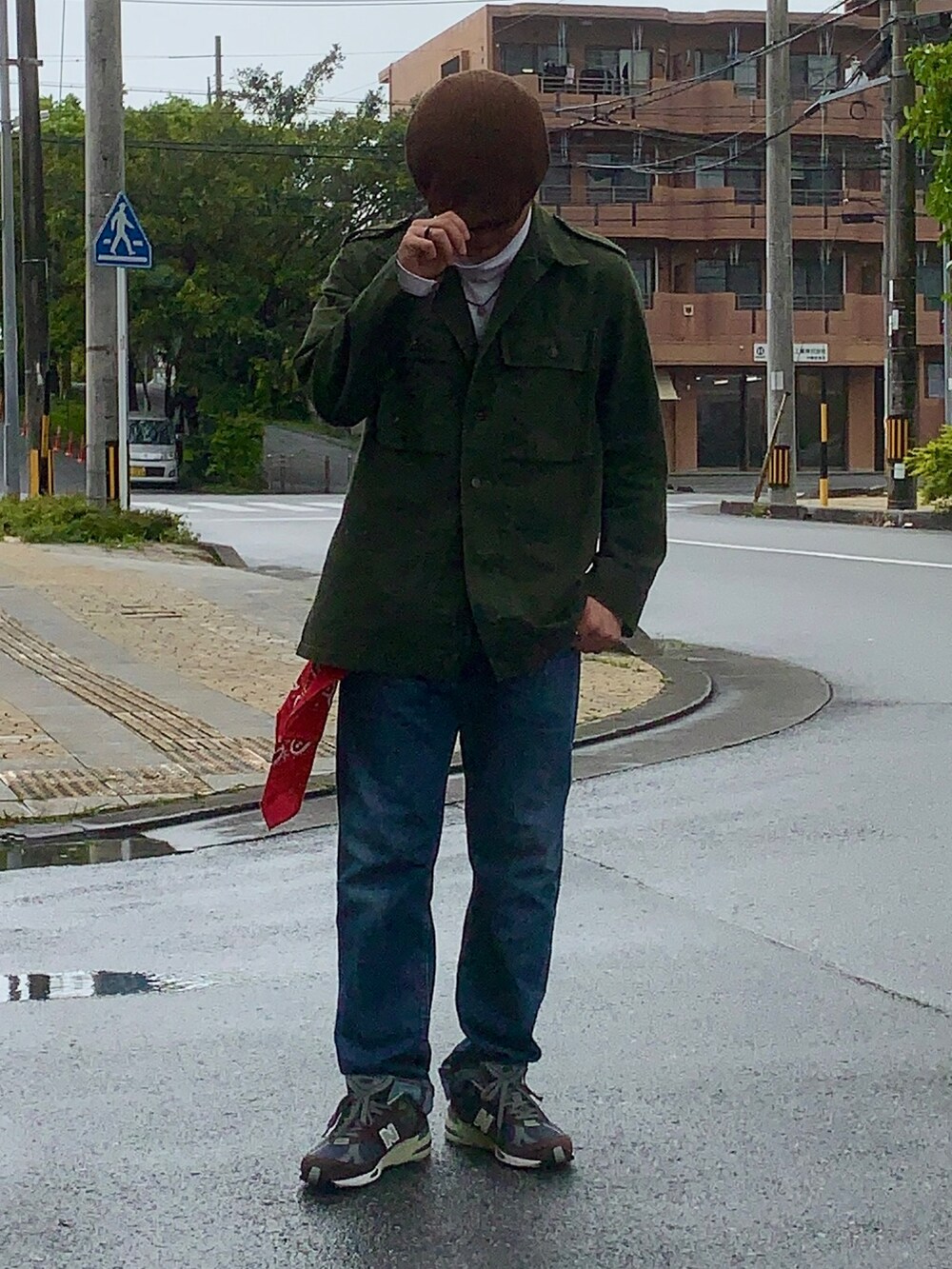 グリーン系のミリタリージャケット、ブラウン系のスニーカー、レッド系のトップスを着用したメンズの春コーディネートの3枚目の写真