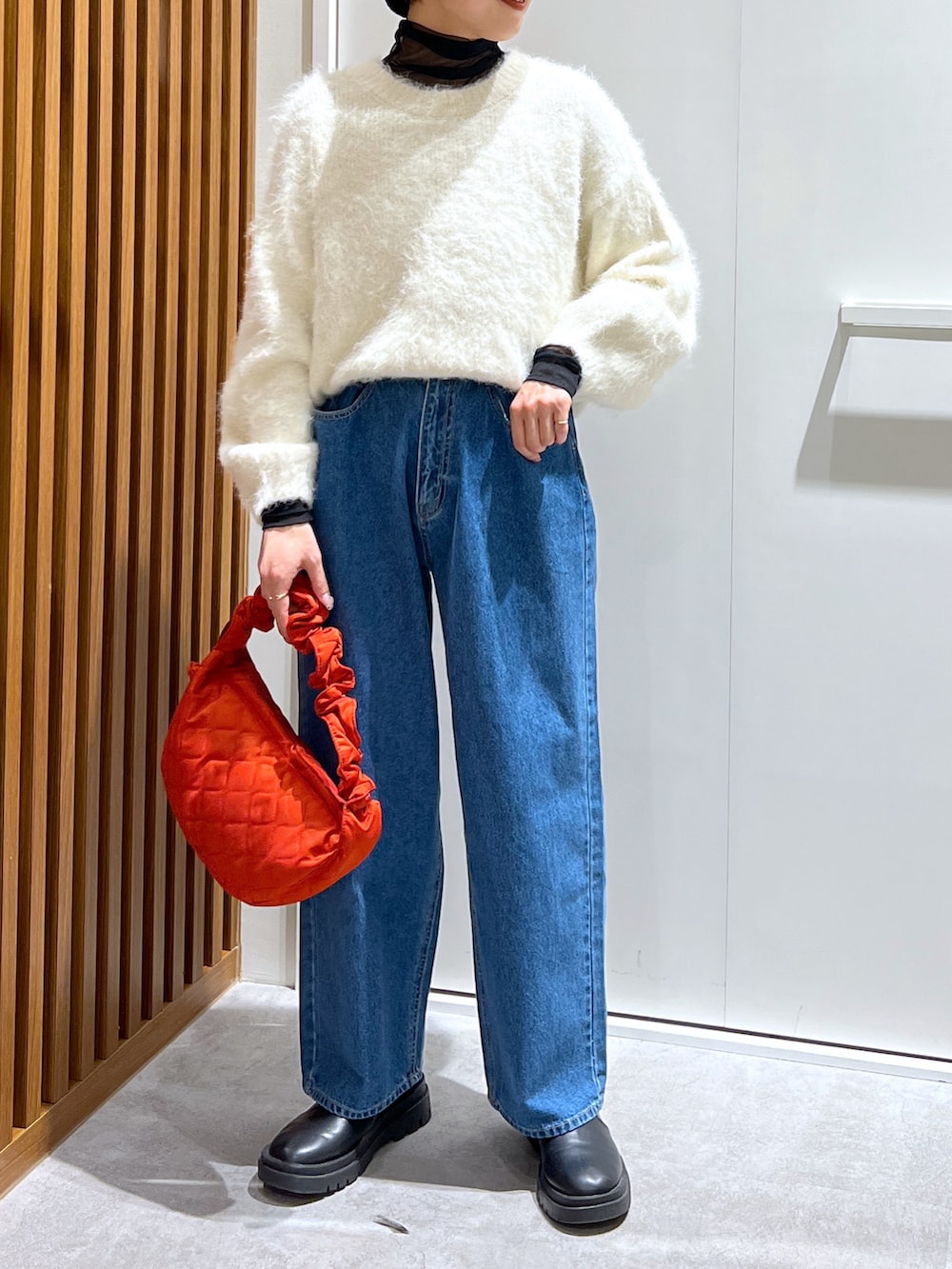 ブラック系のTシャツ/カットソー、ホワイト系のニット/セーター、ブルー系のデニムパンツを着用したレディースの冬コーディネートの3枚目の写真