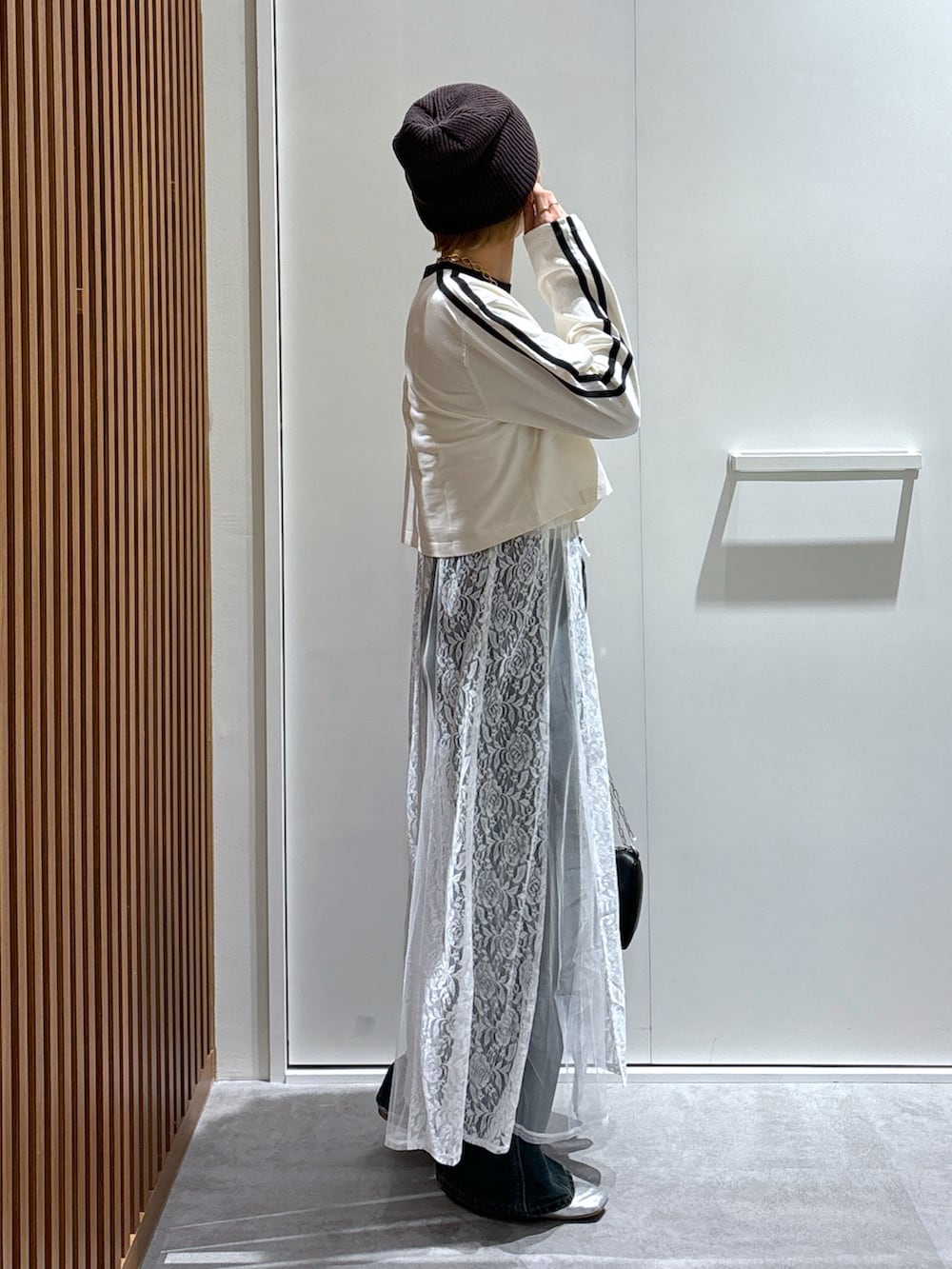 ホワイト系のTシャツ/カットソー、ブラック系のワンピース、ブルー系のデニムパンツを着用したレディースの秋コーディネートの2枚目の写真