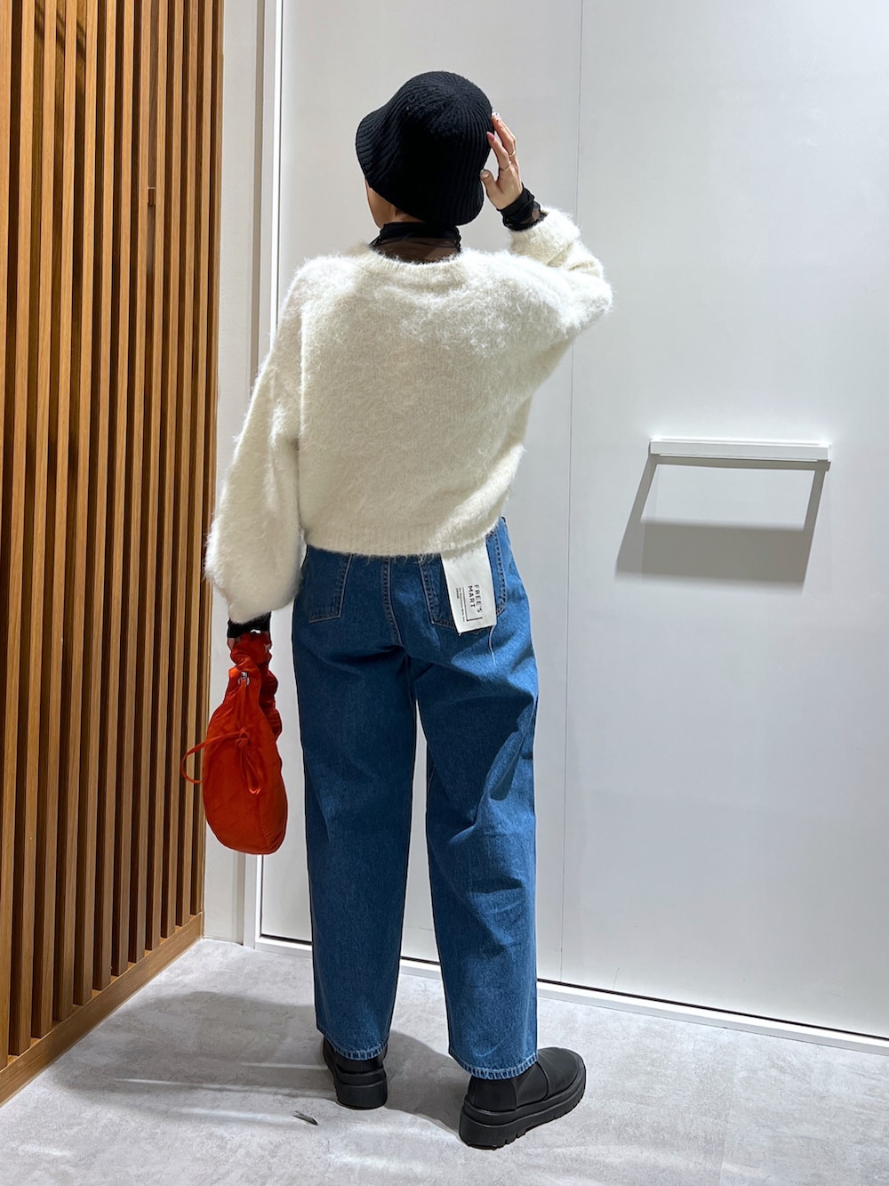 ブラック系のTシャツ/カットソー、ホワイト系のニット/セーター、ブルー系のデニムパンツを着用したレディースの冬コーディネートの2枚目の写真