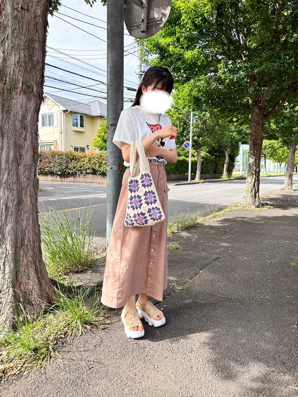 ベージュ系のデニムスカート、ベージュ系のサンダル、ホワイト系のトートバッグを着用したレディースの春コーディネートの2枚目の写真