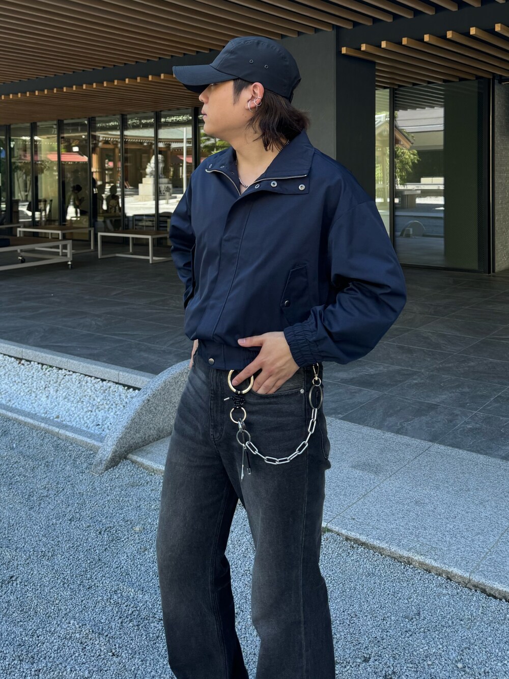 ブラック系のデニムパンツ、ブルー系のブルゾン、シルバー系のネックレスを着用したメンズの秋コーディネートの5枚目の写真