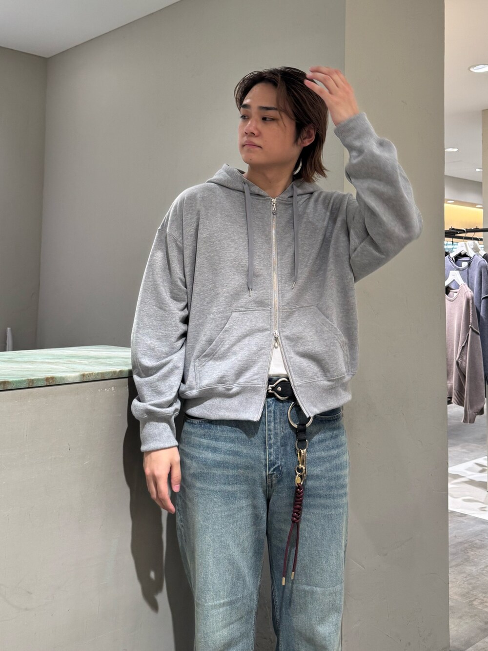 ブルー系のデニムパンツ、グレー系のパーカー、シルバー系のベルトを着用したメンズの秋コーディネートの4枚目の写真