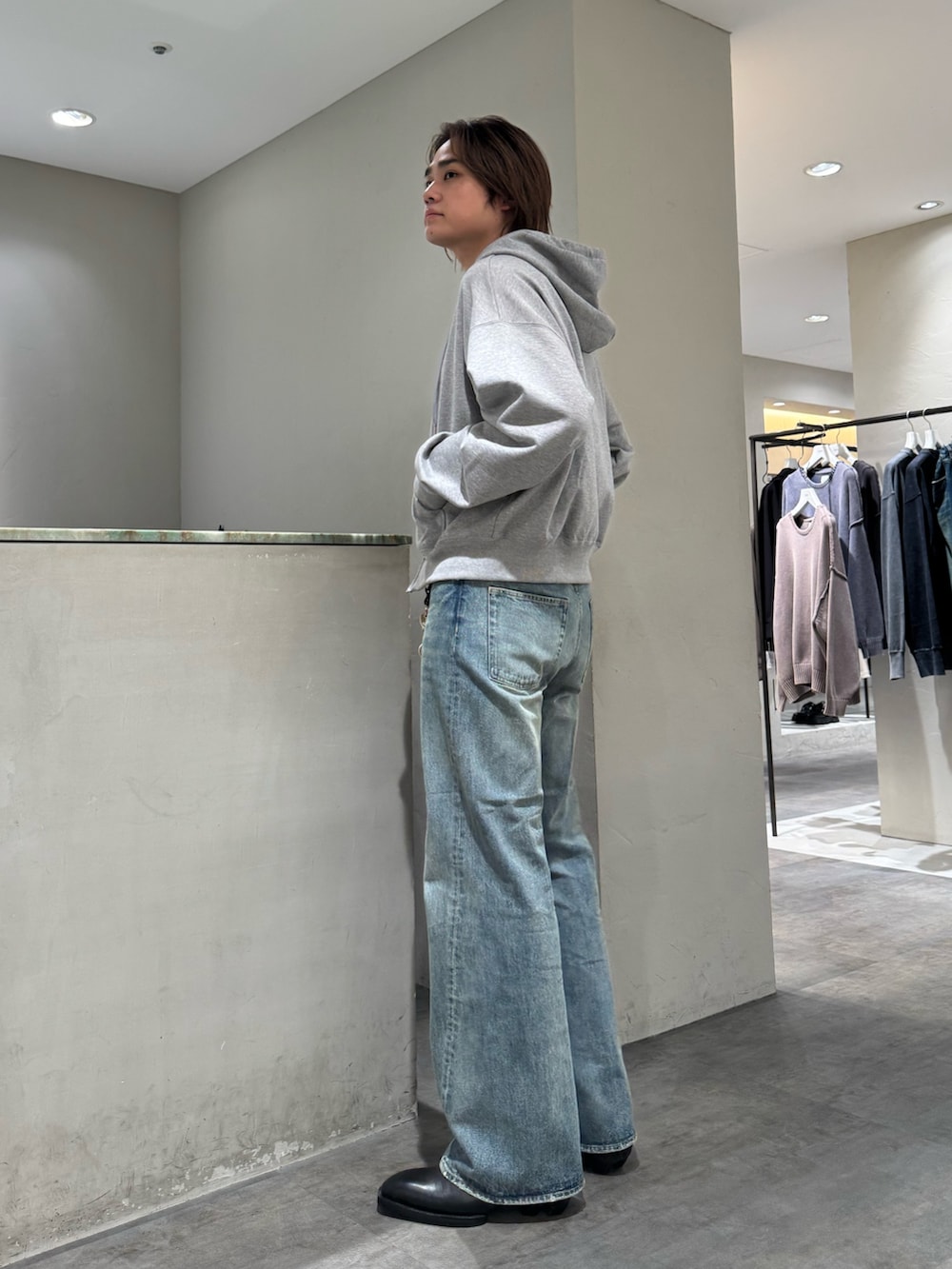 ブルー系のデニムパンツ、グレー系のパーカー、シルバー系のベルトを着用したメンズの秋コーディネートの3枚目の写真