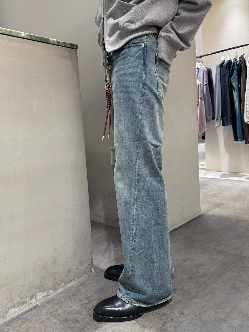 ブルー系のデニムパンツ、グレー系のパーカー、シルバー系のベルトを着用したメンズの秋コーディネートの7枚目の写真