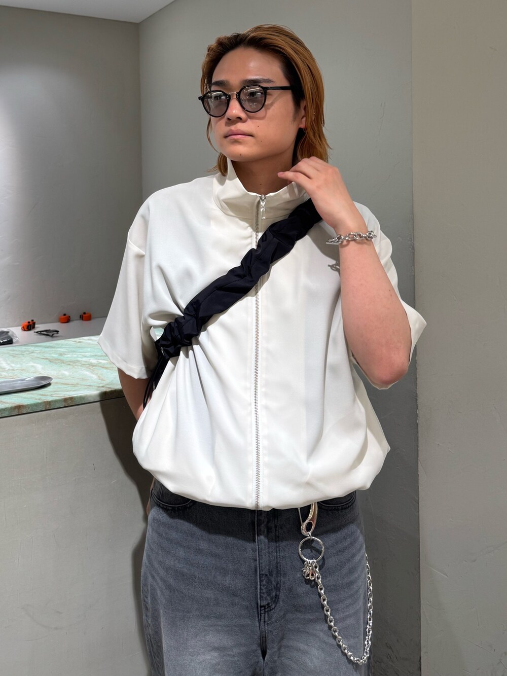 ブラック系のデニムパンツ、ブラック系のショルダーバッグ、グレー系のシャツ/ブラウスを着用したメンズの夏コーディネートの4枚目の写真