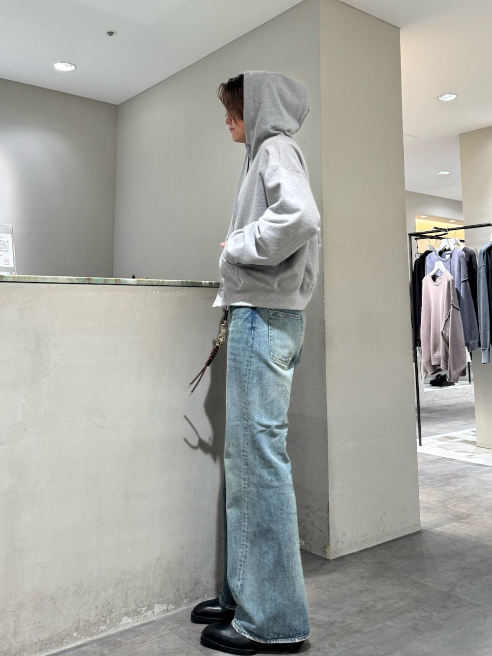 ブルー系のデニムパンツ、グレー系のパーカー、シルバー系のベルトを着用したメンズの秋コーディネートの2枚目の写真