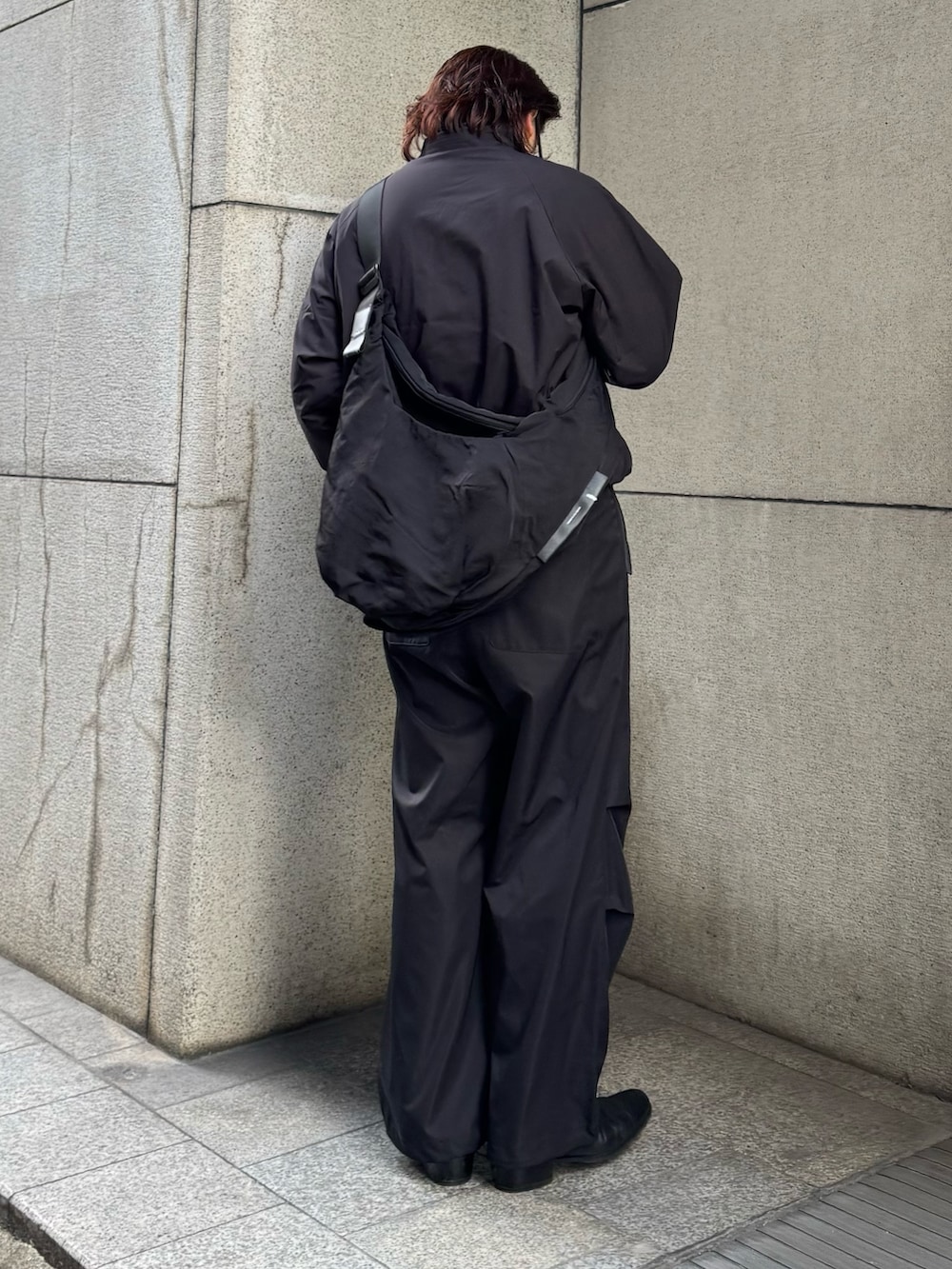 ブラック系のその他パンツ、ブラック系のショルダーバッグ、ブラック系のブルゾンを着用したメンズの冬コーディネートの2枚目の写真