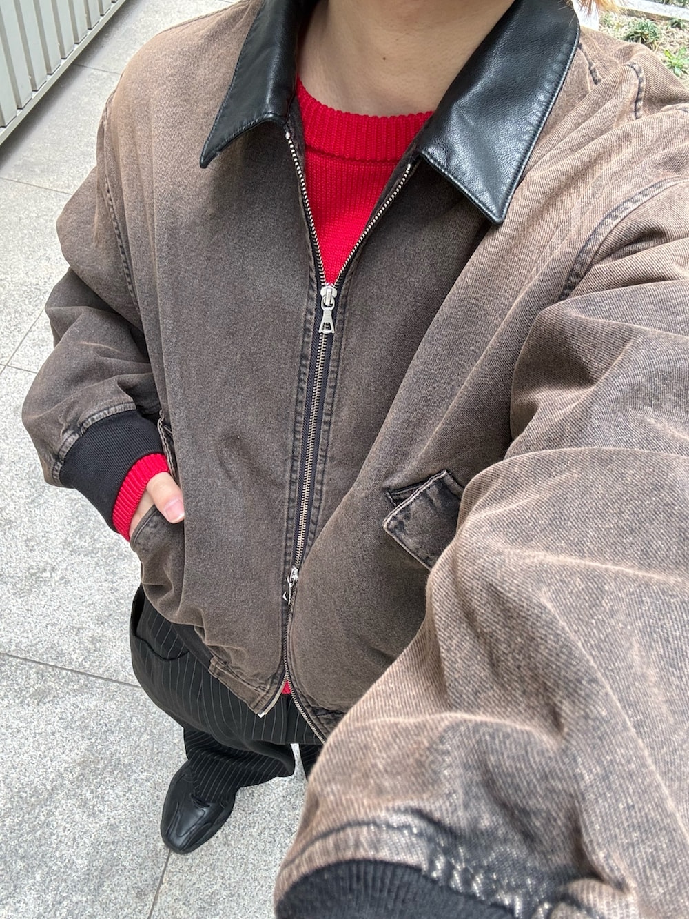 ブラック系のスラックス、ブラウン系のデニムジャケット、レッド系のニット/セーターを着用したメンズの冬コーディネートの6枚目の写真