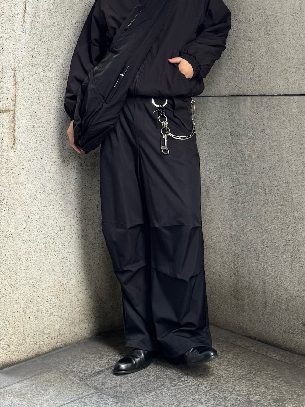 ブラック系のその他パンツ、ブラック系のショルダーバッグ、ブラック系のブルゾンを着用したメンズの冬コーディネートの4枚目の写真