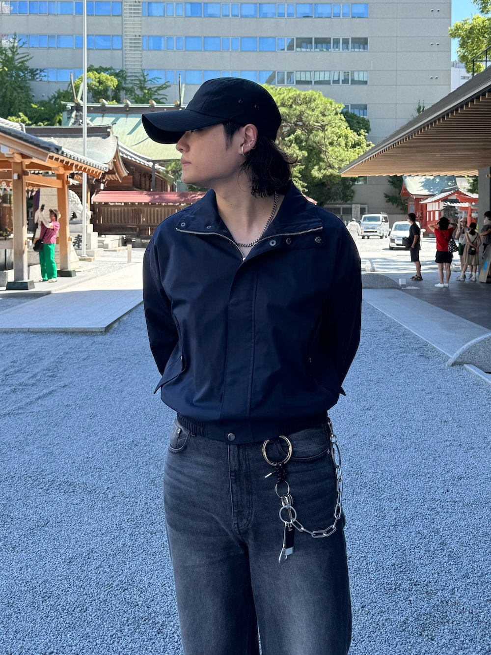 ブラック系のデニムパンツ、ブルー系のブルゾン、シルバー系のネックレスを着用したメンズの秋コーディネートの4枚目の写真