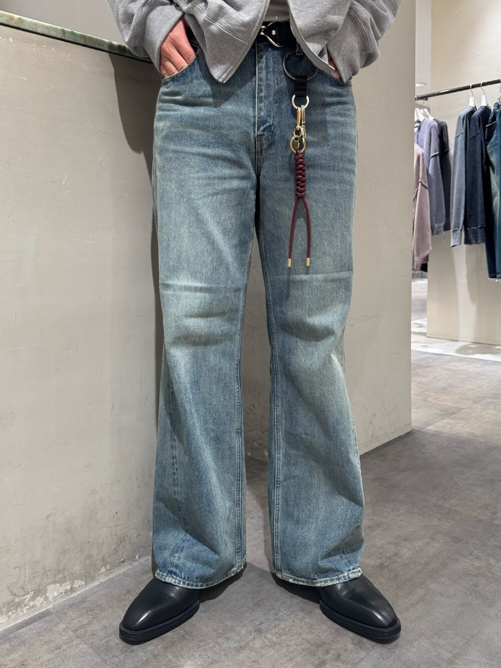 ブルー系のデニムパンツ、グレー系のパーカー、シルバー系のベルトを着用したメンズの秋コーディネートの6枚目の写真