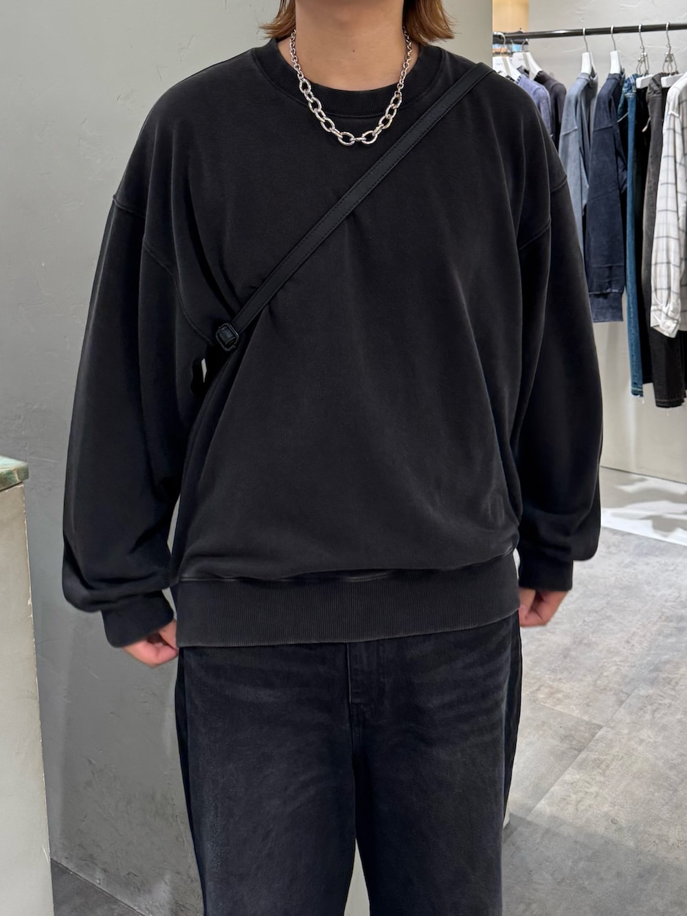 ブラック系のデニムパンツ、ブラック系のスウェット、ブラック系のショルダーバッグを着用したメンズの秋コーディネートの4枚目の写真