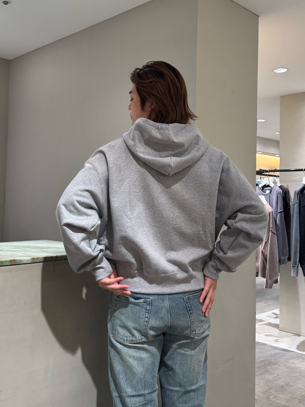 ブルー系のデニムパンツ、グレー系のパーカー、シルバー系のベルトを着用したメンズの秋コーディネートの5枚目の写真