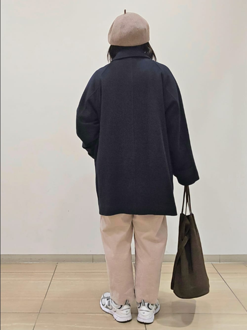 グレー系のピーコート、グレー系のその他パンツ、ホワイト系のTシャツ/カットソーを着用したレディースの秋コーディネートの2枚目の写真