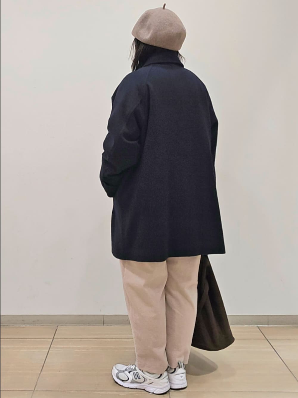 グレー系のピーコート、グレー系のその他パンツ、ホワイト系のTシャツ/カットソーを着用したレディースの秋コーディネートの3枚目の写真