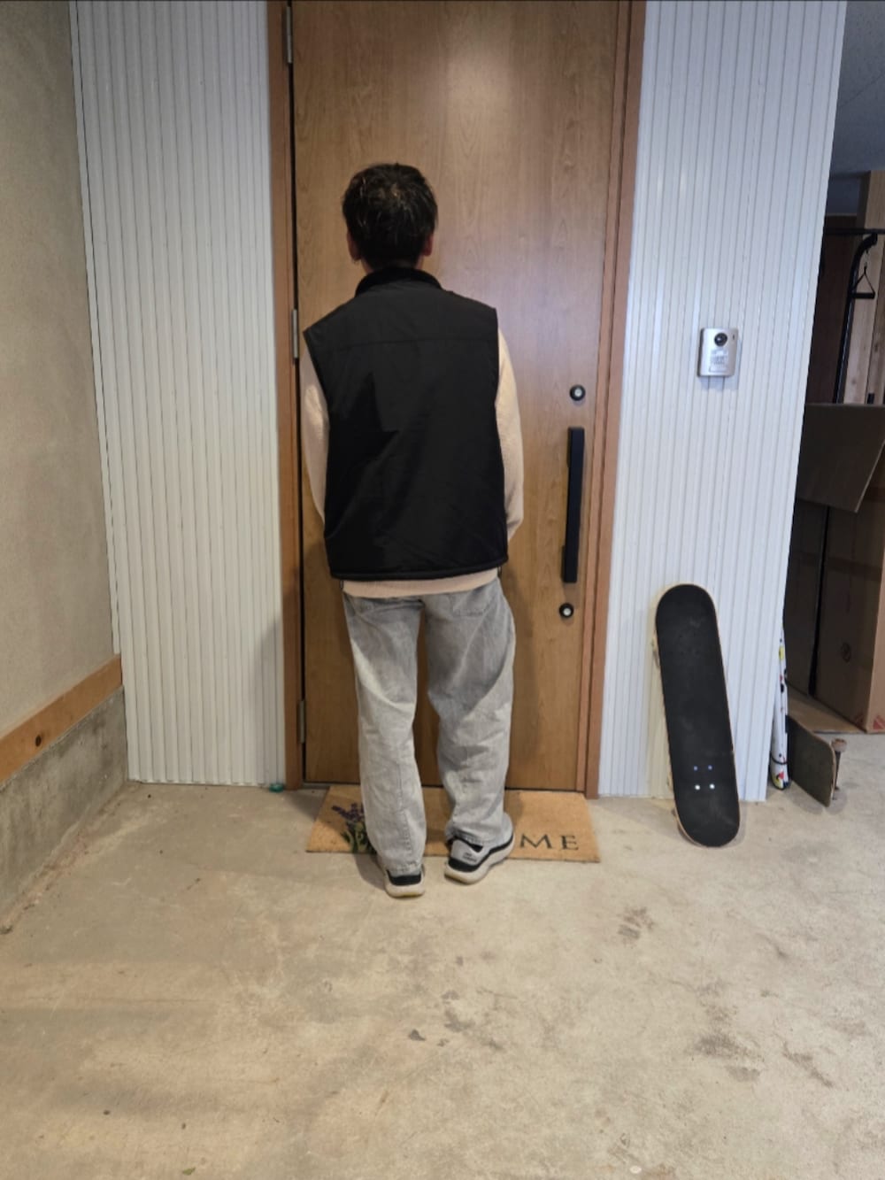 ホワイト系のニット/セーター、ブラック系のその他アウター、グレー系のデニムパンツを着用したメンズの冬コーディネートの3枚目の写真