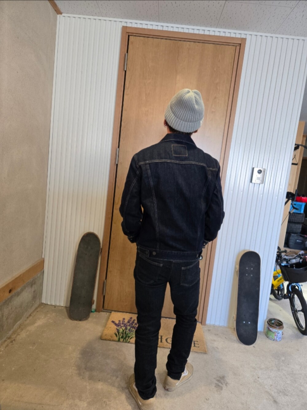 ブラック系のデニムジャケット、ブラック系のデニムパンツ、ベージュ系のスニーカーを着用したメンズの秋コーディネートの3枚目の写真