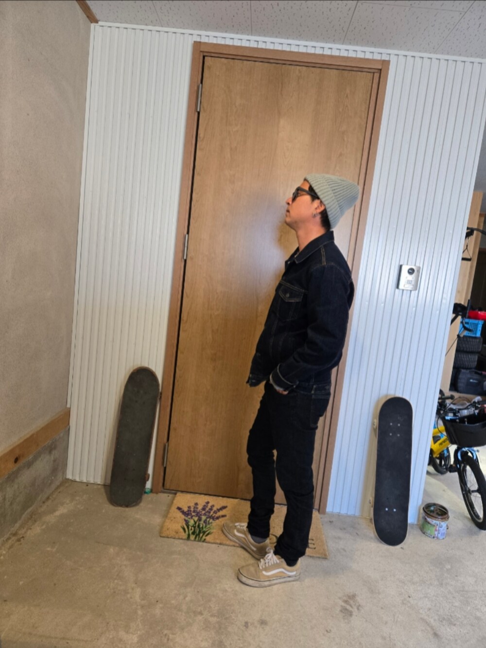 ブラック系のデニムジャケット、ブラック系のデニムパンツ、ベージュ系のスニーカーを着用したメンズの秋コーディネートの2枚目の写真