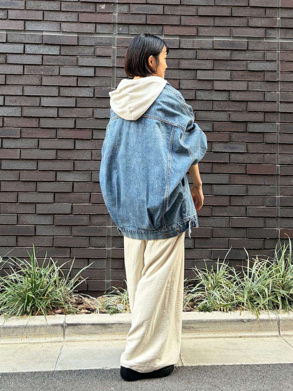ブルー系のデニムジャケット、ホワイト系のその他パンツ、ホワイト系のパーカーを着用したレディースの秋コーディネートの3枚目の写真
