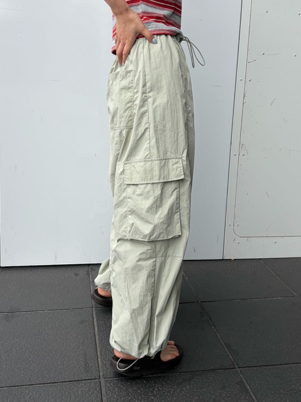 レッド系のTシャツ/カットソー、グリーン系のその他パンツ、ブラウン系のキャップを着用したレディースの夏コーディネートの5枚目の写真